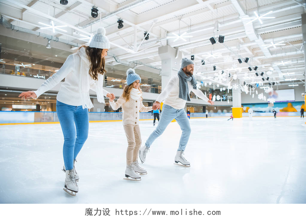 一家人在溜冰场上溜冰微笑的家庭手牵手, 而一起在溜冰场上溜冰